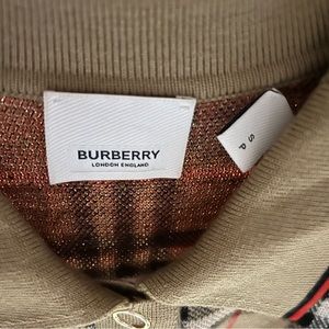 The brand is BURBERRY. The colors are tan like , red, and black.